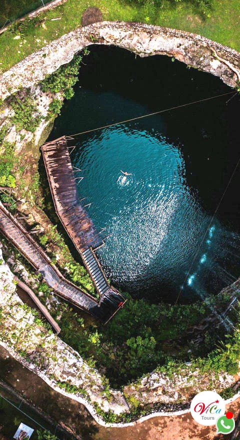 Toma aérea del cenote tipo abierto rodeado de vegetación mística, entrada incluida en el tour desde Costa Mujeres
